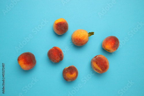 Flat lay composition with fresh peaches on blue background. Fresh organic fruit, vegan food. Harvest concept.
