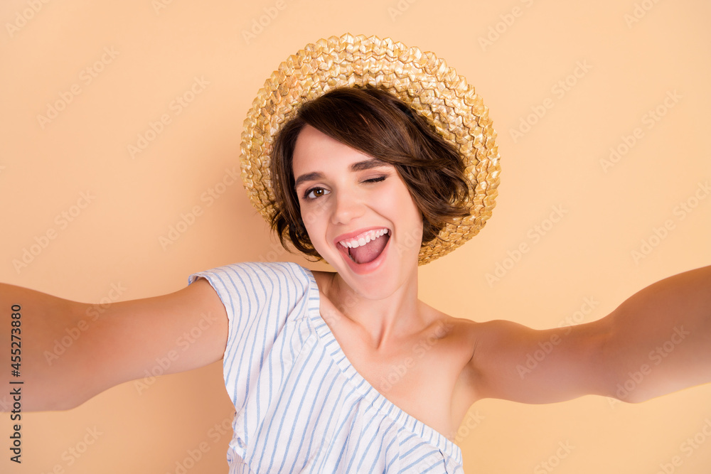 Photo of young attractive girl happy positive smile wink eye make selfie trip isolated over beige color background Photo of young attractive girl happy positive smile wink eye make selfie trip isolated over beige color background