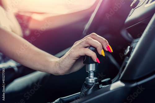 Fotografi female driver hand shifting gear shift knob manually before the beginning of rid