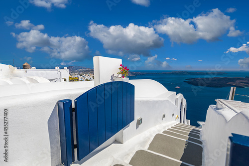 White washed staircases on Santorini Island. Scenic caldera view with blue door, blue sunny sky. Amazing travel landscape, summer vacation destination. Idyllic street in Greece. Tourism background