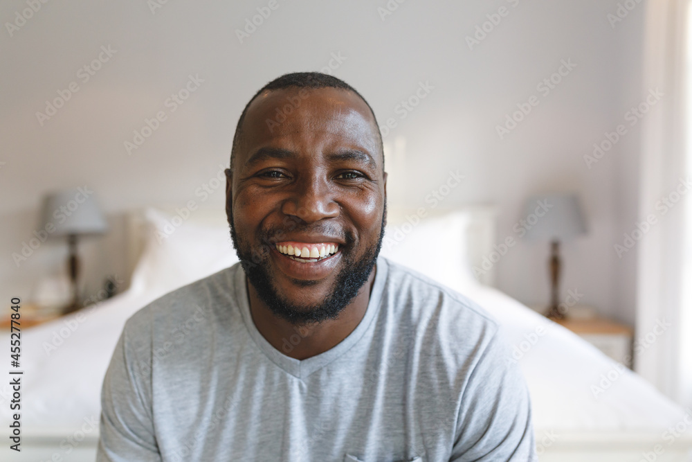 Portrait of happy african american man looking at camera and smiling in bedroom Portrait of happy african american man looking at camera and smiling in bedroom