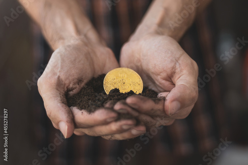 hands picking up a bitcoin from the ground
mining concept. photo