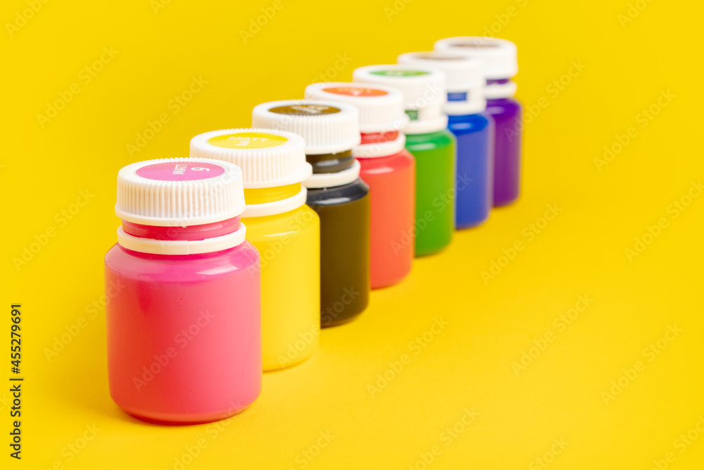Color oil paint bottles on yellow background Color oil paint bottles on yellow background