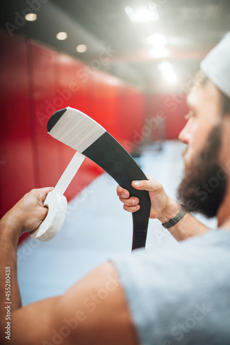 Canvas Print Preparing the hockey stick for play - wrapping tape around the handle and hook f