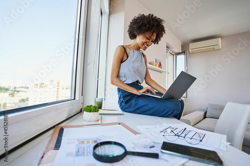 Joyous draftswoman working on the portable computer photo