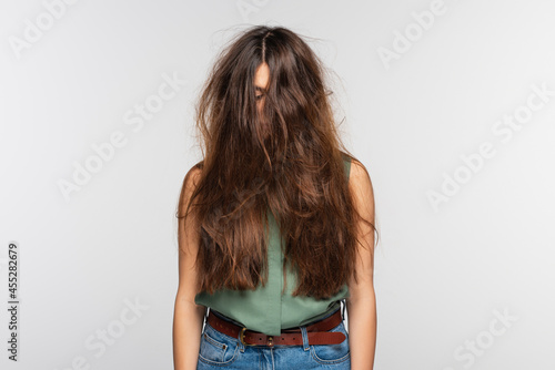 young woman with tangled long hair isolated on grey