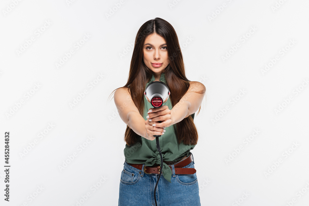 Obraz premium young woman with shiny hair holding hair dryer while aiming isolated on grey