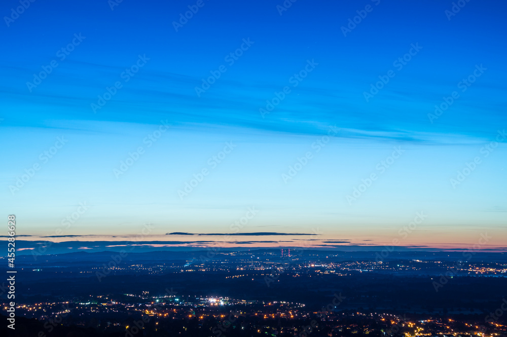 Looking across a mixture of the countryside and towns scattered with street lights just before sunrise. Looking down from the Malvern Hills, Worcestershire, UK. Looking across a mixture of the countryside and towns scattered with street lights just before sunrise. Looking down from the Malvern Hills, Worcestershire, UK.