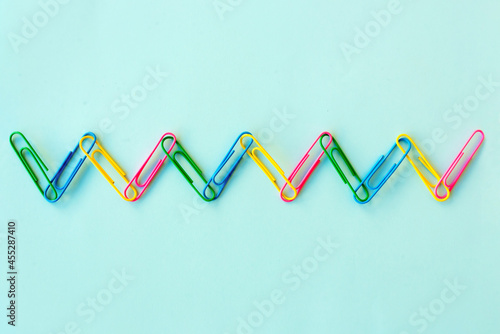Colorful paper clips stuck together in a chain. Concept of human diversity, equality, connection, and friendship © Viktoriia