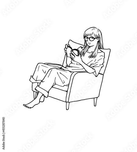 文庫本をソファで読む女性