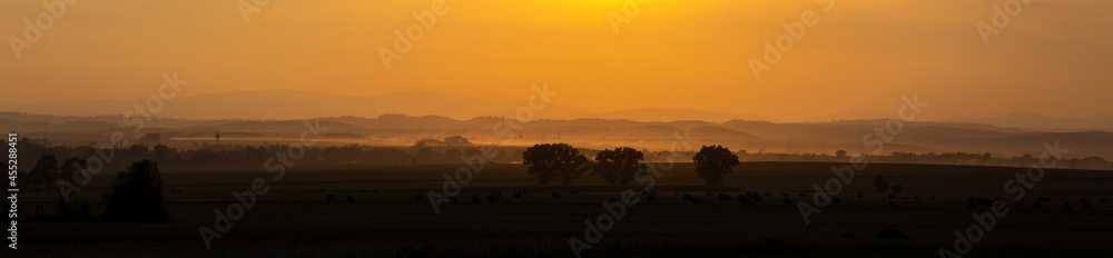 Orange sunset over the fields. Good lighting conditions, distant planes visible