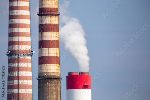 A close-up of the smoking stacks of a coal-fired power plant. Photo taken on a sunny day with good lighting conditions.