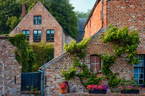 Old housesof Begijnhof Beguinage with flowers in Bruges, Belgium