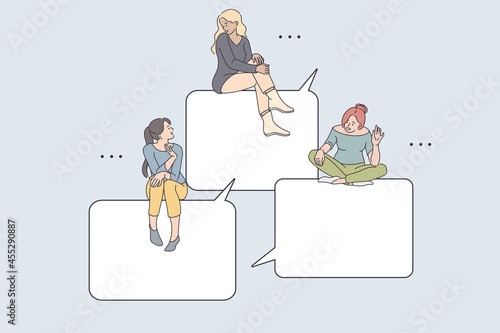 Internet communication and chatting concept. Young smiling girls friends sitting on speech bubbles greeting each other online from smartphone screen online vector illustration 
