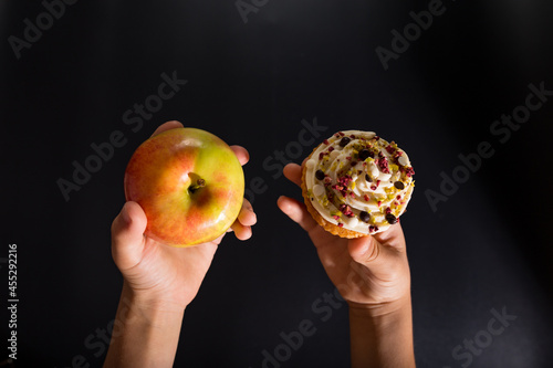 Fotografía Healthy eating principles Hands with apple and muffin.
