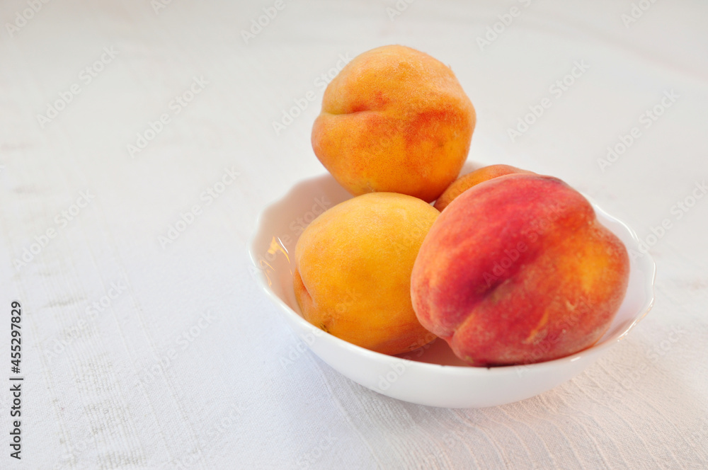 Tasty juicy peaches close up on whine table cloth, free space for ypur text Tasty juicy peaches close up on whine table cloth, free space for ypur text