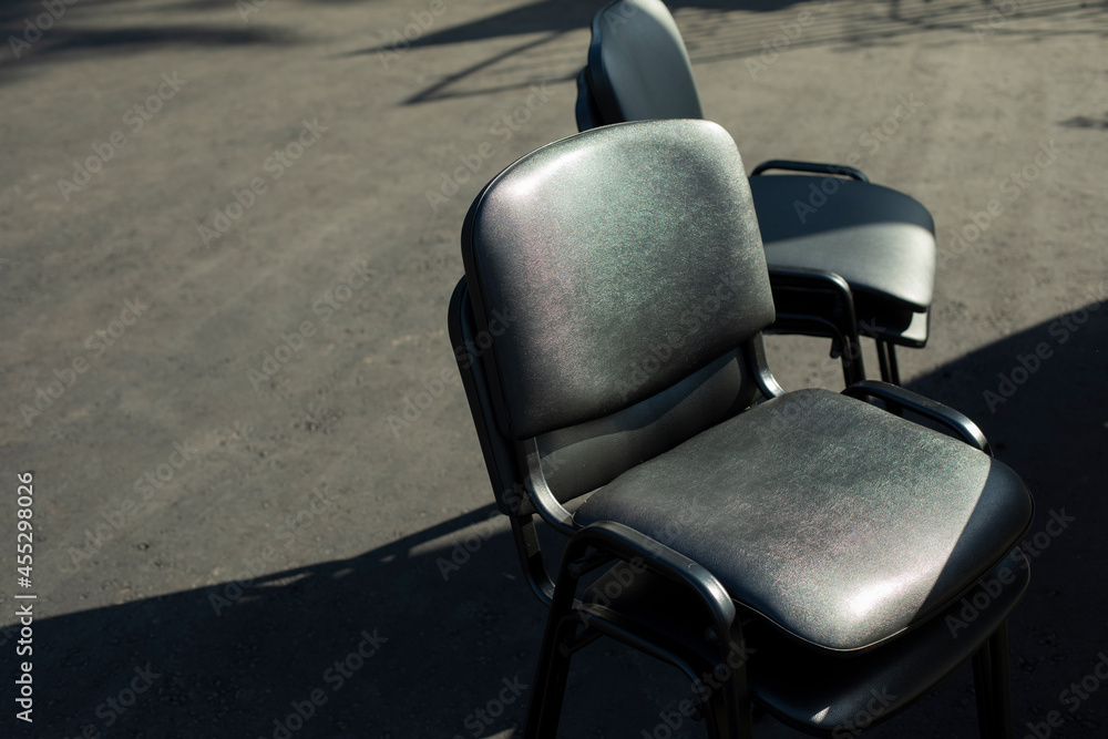 Black chairs stand outside. Office furniture in black.