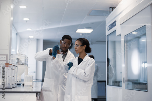 Female scientist discussing results of experiment with male colleague
