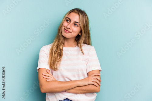Young caucasian blonde woman isolated on blue background dreaming of achieving goals and purposes
