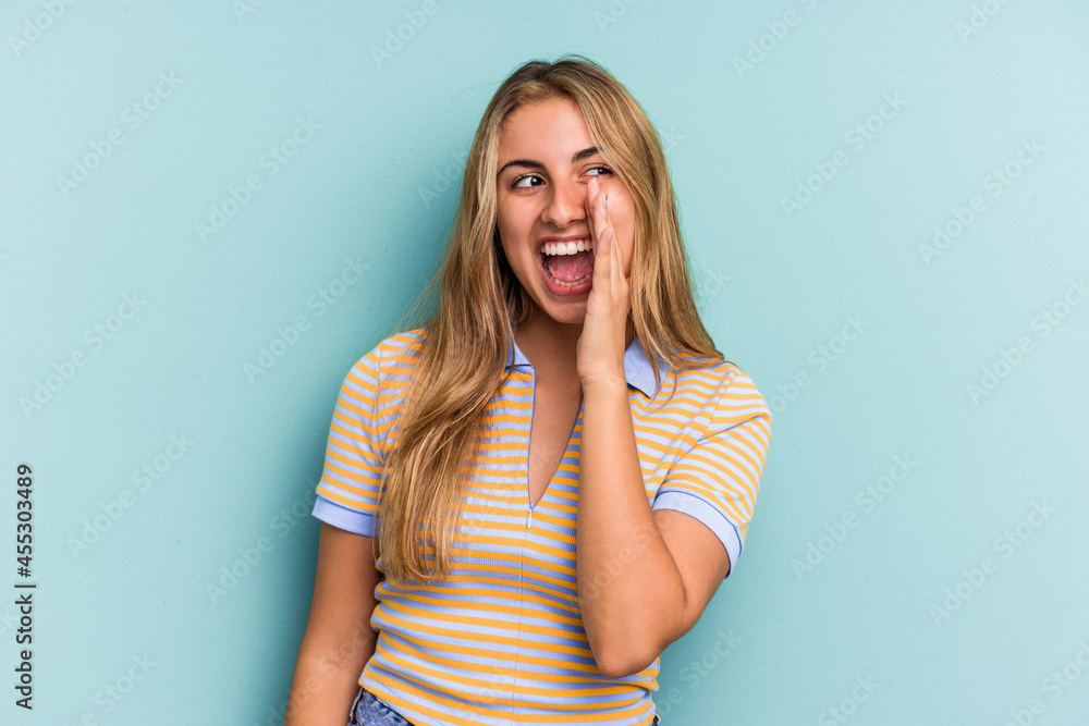 Young caucasian blonde woman isolated on blue background shouting excited to front. Young caucasian blonde woman isolated on blue background shouting excited to front.