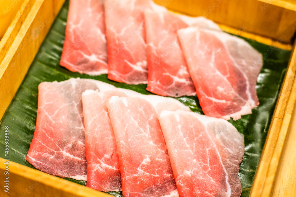 Sliced pork set in a wooden bowl inside the restaurant Sliced pork set in a wooden bowl inside the restaurant