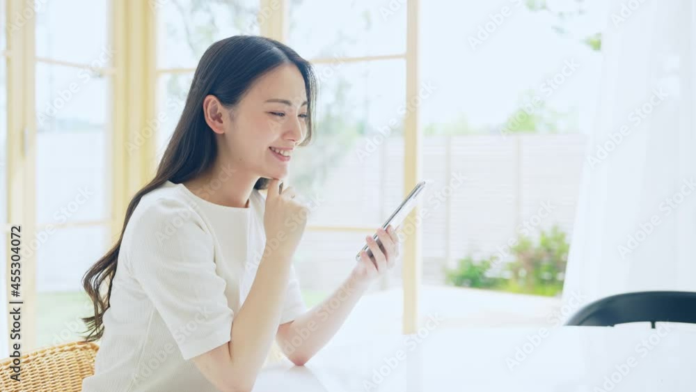 笑顔でスマホを見る女性