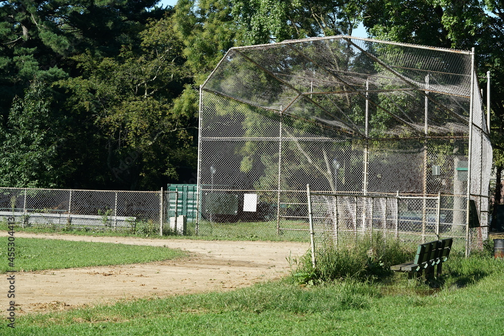 Baseball metal backstop and field in park in summer Baseball metal backstop and field in park in summer