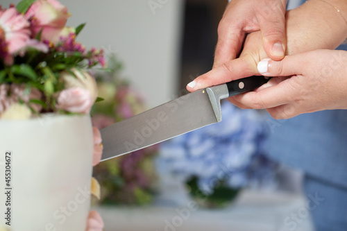 Detail of bride and groom cutting wedding cake after getting married. High quality photo