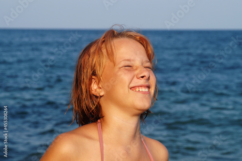 laughing teenage girl on the background of the sea horizon portrait