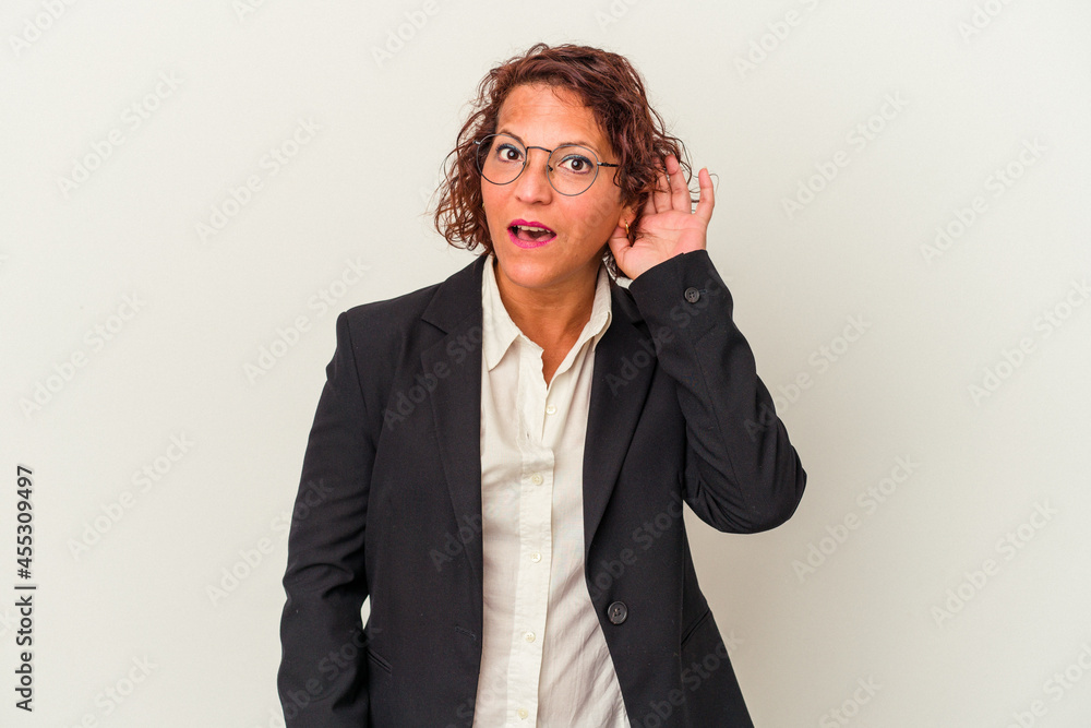 Middle age latin business woman isolated on white background trying to listening a gossip. Middle age latin business woman isolated on white background trying to listening a gossip.