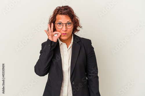 Middle age latin business woman isolated on white background with fingers on lips keeping a secret.