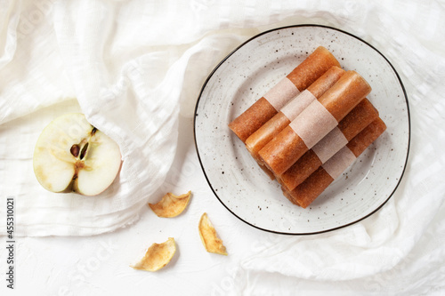 Pastille fruit rolls, apple marshmallow on a plate and white tablecloth. Healthy sweets.