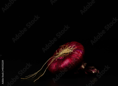 close-up red onion isolated on black background with blank space for a text