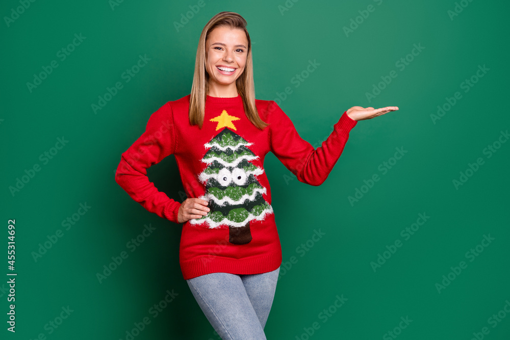 Portrait of attractive cheerful confident girl demonstrating on palm copy space ad solution isolated over green color background Portrait of attractive cheerful confident girl demonstrating on palm copy space ad solution isolated over green color background