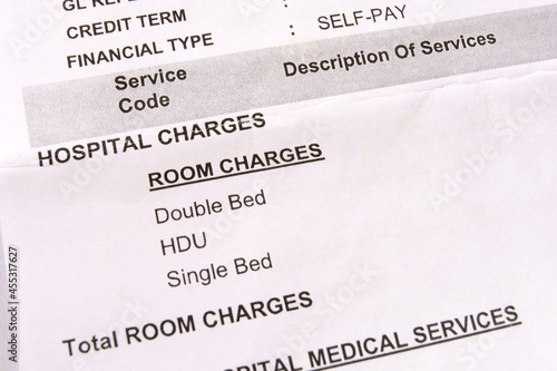Closeup macro view of an itemized hospital bill for medical services during a hospital stay. A medical bill for hospitalization listing an uninsured patient's medical treatment and healthcare cost. photo