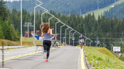 Young slim woman running on the road in the morning © skumer