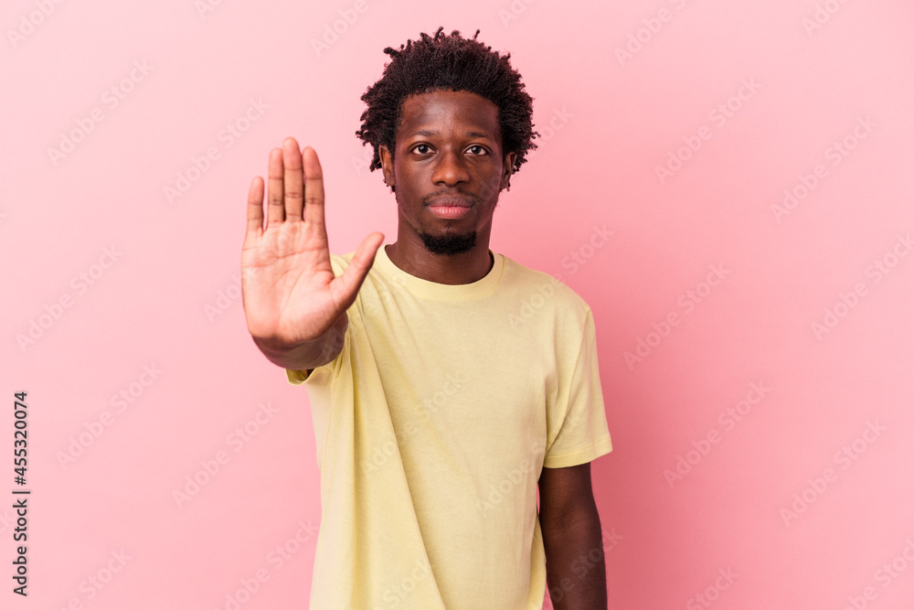 Young african american man isolated on pink background standing with outstretched hand showing stop sign, preventing you. Young african american man isolated on pink background standing with outstretched hand showing stop sign, preventing you.
