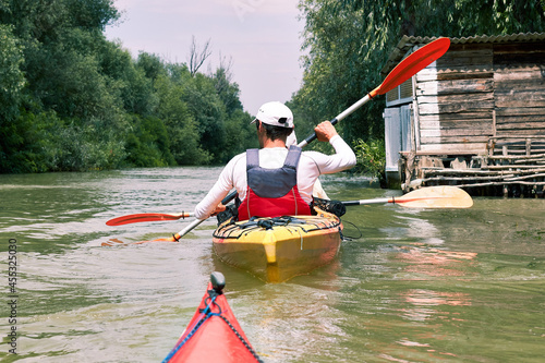 Couple kayaking on Danube river in Vilkovo. Having fun in leisure activity. Woman and man on the kayak. Sport, relations concept. Rear view
