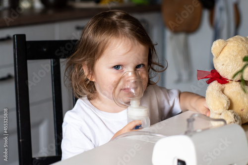 the child breathes through a nebulizer mask. treatment of cough in children. inhalation with a nebulizer. colds and their treatment in children. treatment of lung infections at home. sore throat