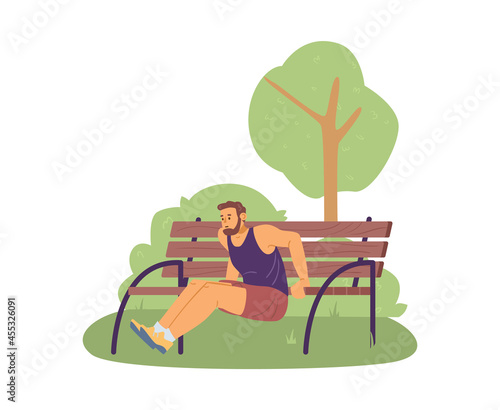 Young man in sportswear doing sport exercises, training push-ups from bench.
