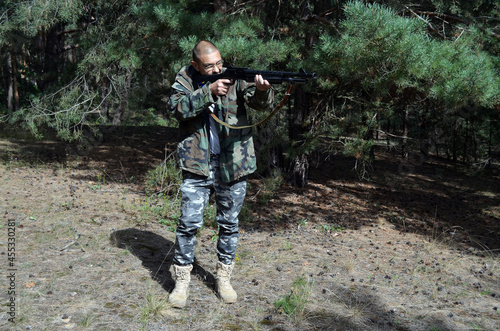 Mature man with 12-gauge rifle (pump action shotgun). Unformal shooting range near Kiev. Ukraine