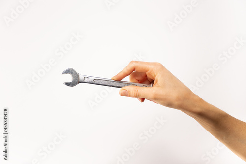 Mano sosteniendo herramienta, llave española, fondo blanco. 