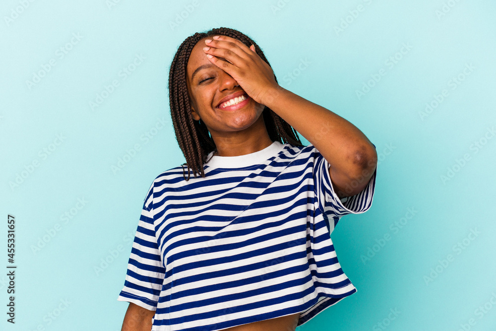 Young african american woman isolated on blue background laughing happy, carefree, natural emotion. Young african american woman isolated on blue background laughing happy, carefree, natural emotion.