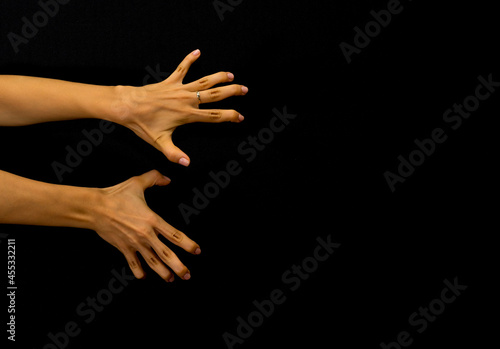 Woman's hands with unusual shapes of fingers against black background