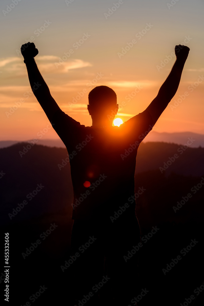 Fototapeta premium Free man raising arms to golden sunset summer sky. Freedom, success and hope concept