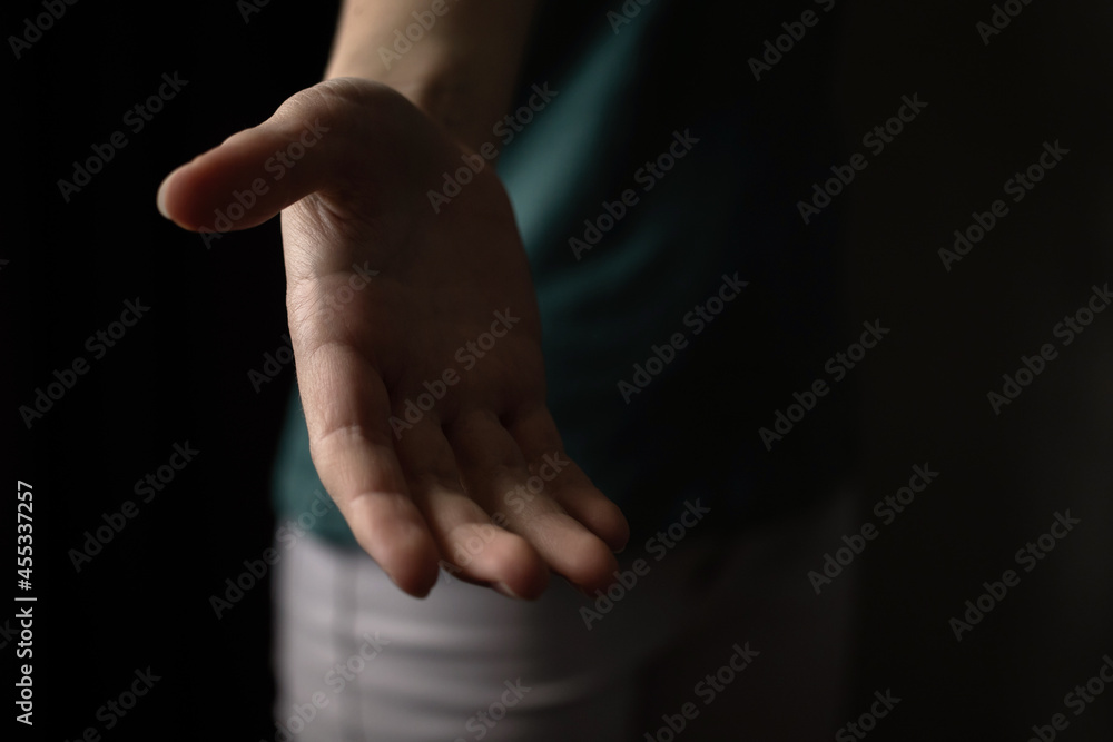 Helping hand in the dark. Gesture by young woman, copy space photo Helping hand in the dark. Gesture by young woman, copy space photo