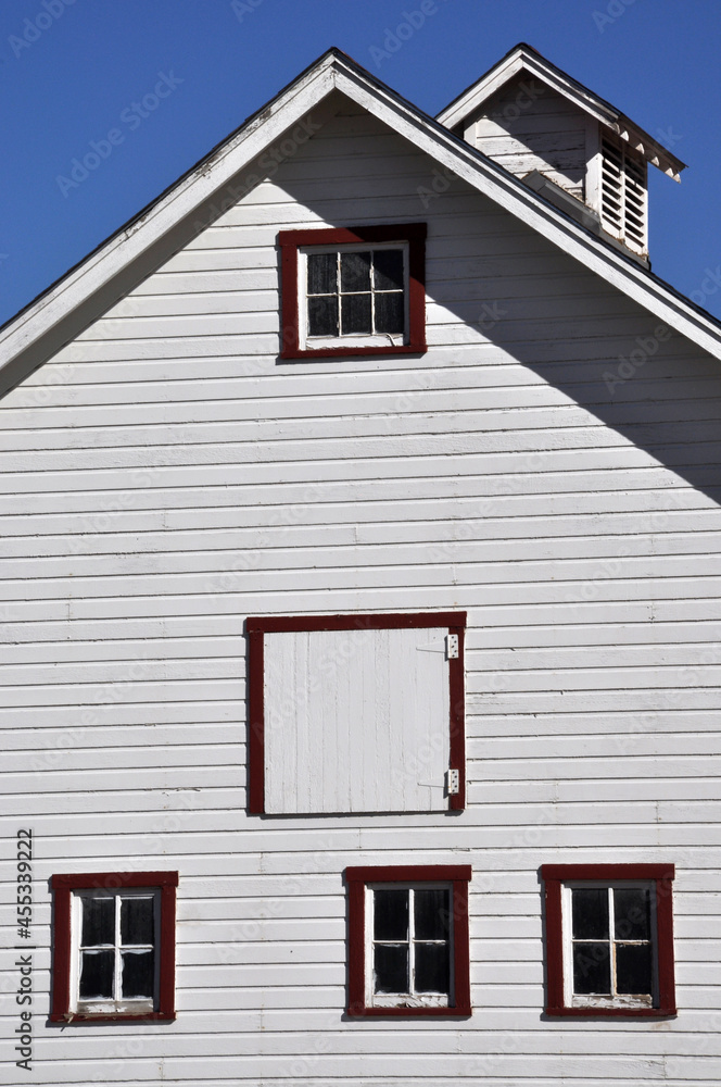 White wooden rural generic barn with windows and door