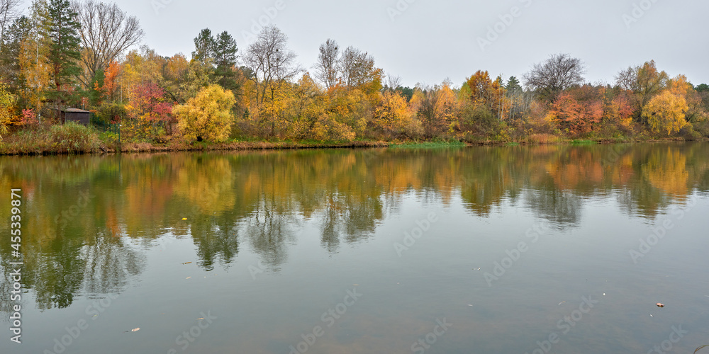 Autumn forest on the banks of the calm river.