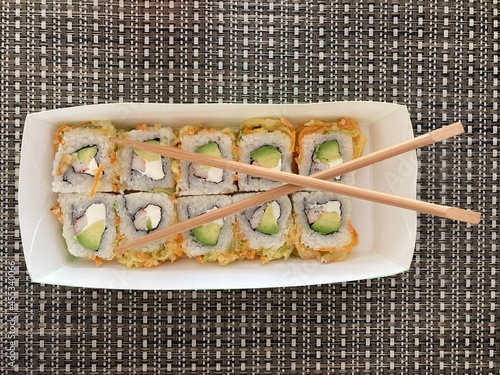 Sushi con palillos en toma cenital sobre mantel