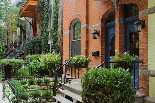 Colored houses with green hydrangea in Montreal, Plateau Mont Royal neighborhood during housing crisis of 2021 with homes and apartment prices reducing mortgage possibilities in gentrification area